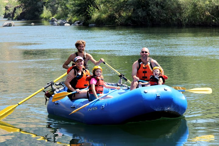 A family rafting on calm waters in the Trinity River