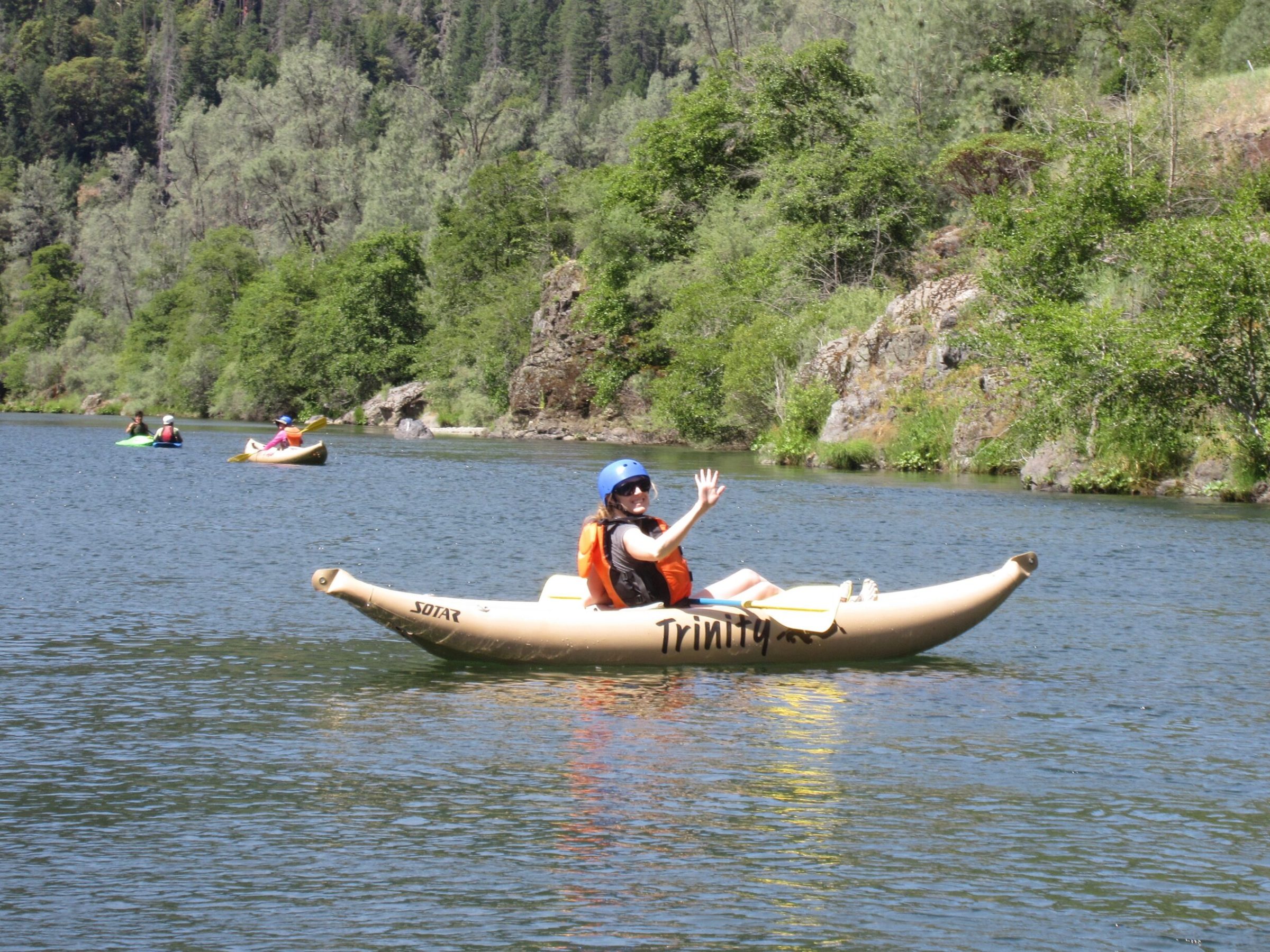 a man riding a boat on a lake next to a body of water