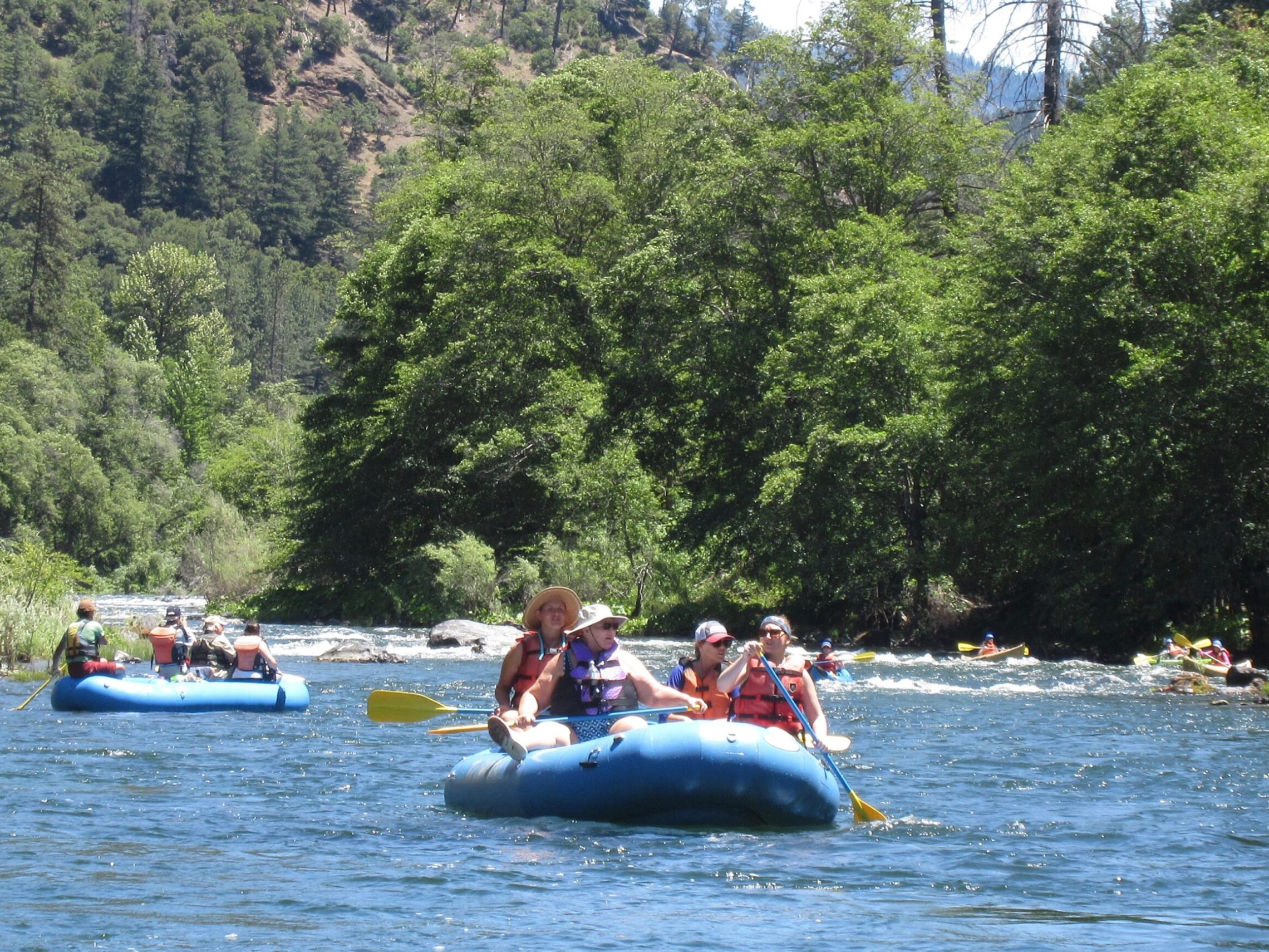 a group of people riding on the back of a boat in the water