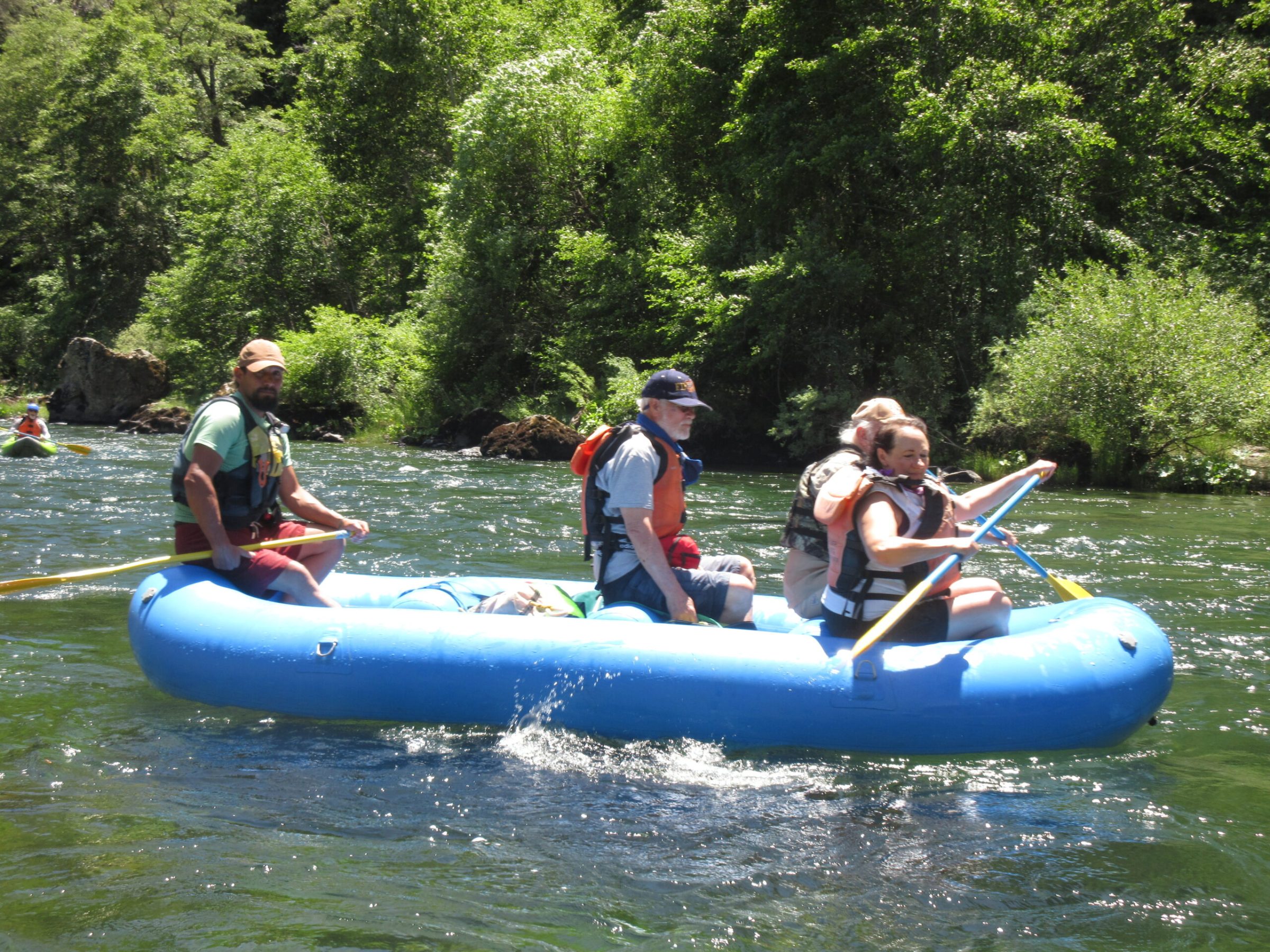 a group of people riding on the back of a boat in the water